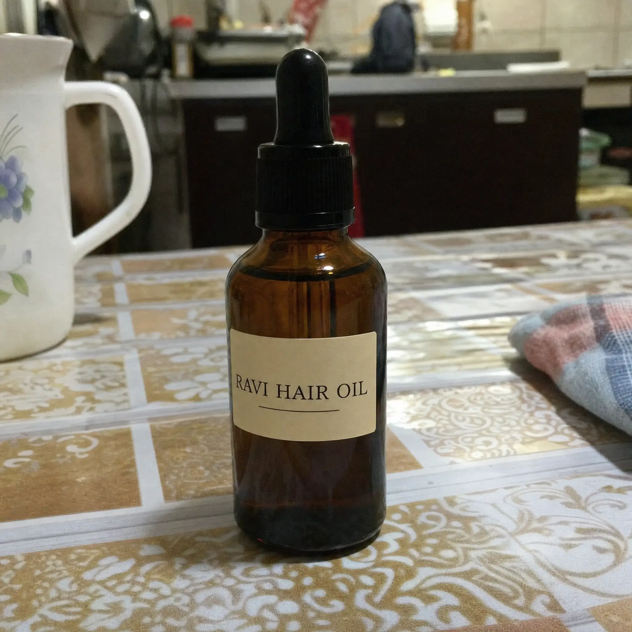 A bottle of hair oil photographed at home on a kitchen table